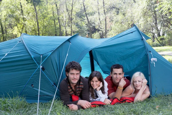 Persone sdraiate in tenda e guardando la macchina fotografica — Foto Stock