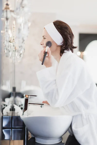 Kvinna i badrock tillämpa makeup — Stockfoto