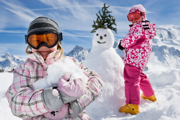 Dos chicas con un muñeco de nieve — Foto de Stock
