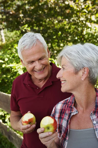 Senior couple eating apples