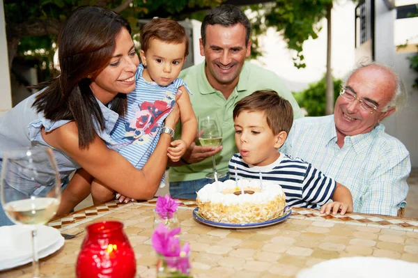 ケーキの上にろうそくを吹いて家族 — ストック写真