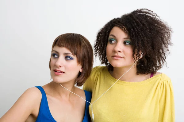 Meninas adolescentes compartilhando fones de ouvido — Fotografia de Stock