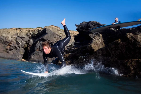 Man jumping onto surfboard — Stock Photo, Image