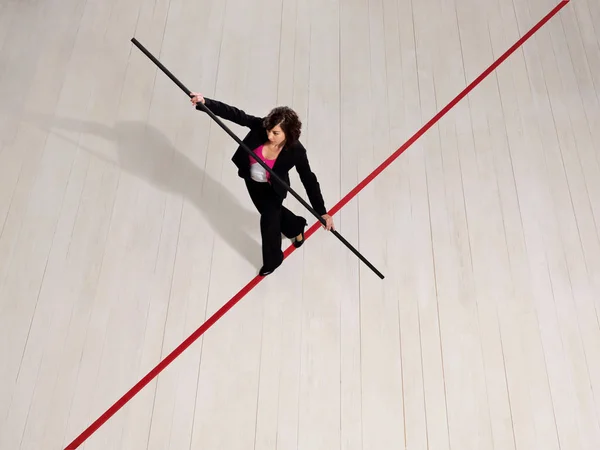 Деловая женщина балансирует на красной линии — стоковое фото