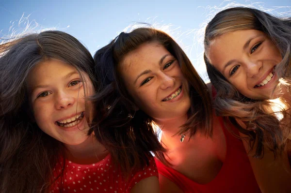 Девушки улыбаются на фоне голубого неба — стоковое фото