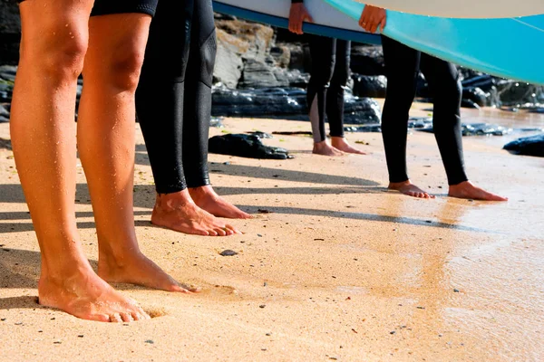 Quattro persone gambe sulla spiaggia — Foto Stock
