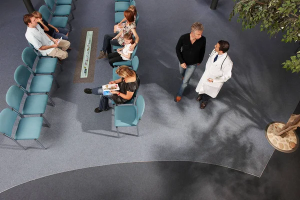 Doctor and patients in waiting area — Stock Photo, Image