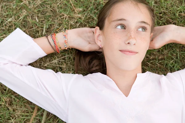 Chica acostada en la hierba y mirando hacia otro lado —  Fotos de Stock