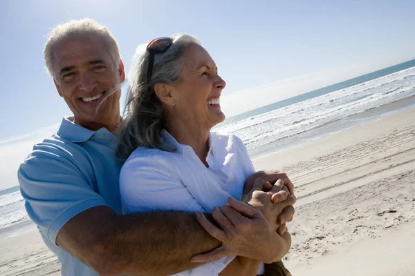 Starszy człowiek żona ogarnięcie na plaży — Zdjęcie stockowe