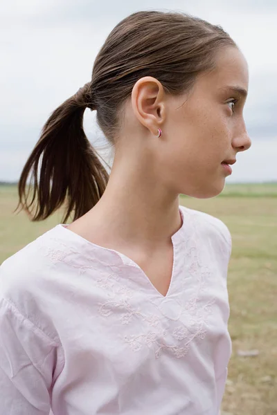 Meisje in het veld op zoek weg — Stockfoto