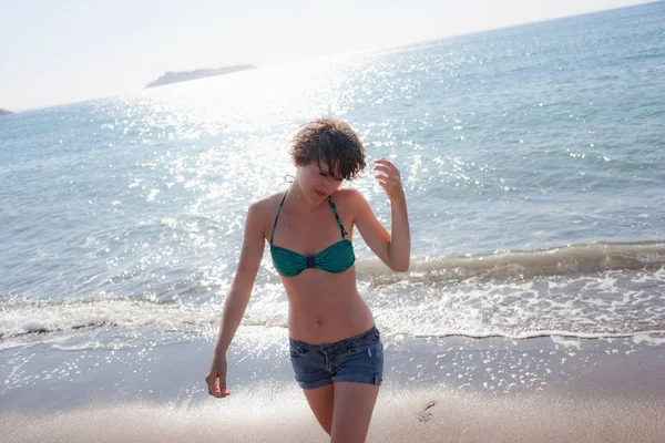 Vrouw in bikini wandelen op het strand — Stockfoto