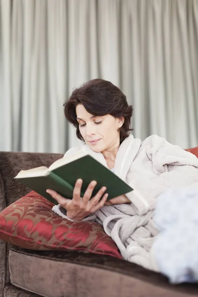 Жінка в халаті читає книгу — стокове фото