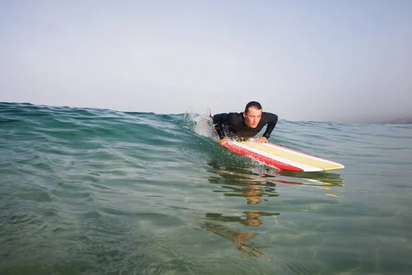 Homme allongé sur planche de surf — Photo