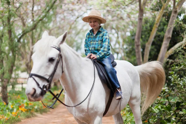 Glimlachend jongen paardrijden paard in park — Stockfoto