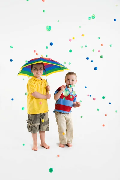 Jungen stehen mit buntem Regenschirm — Stockfoto
