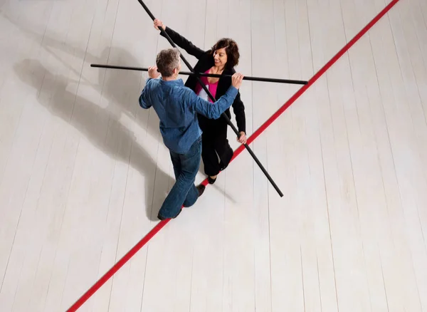 Мужчина и женщина балансируют на красной линии — стоковое фото