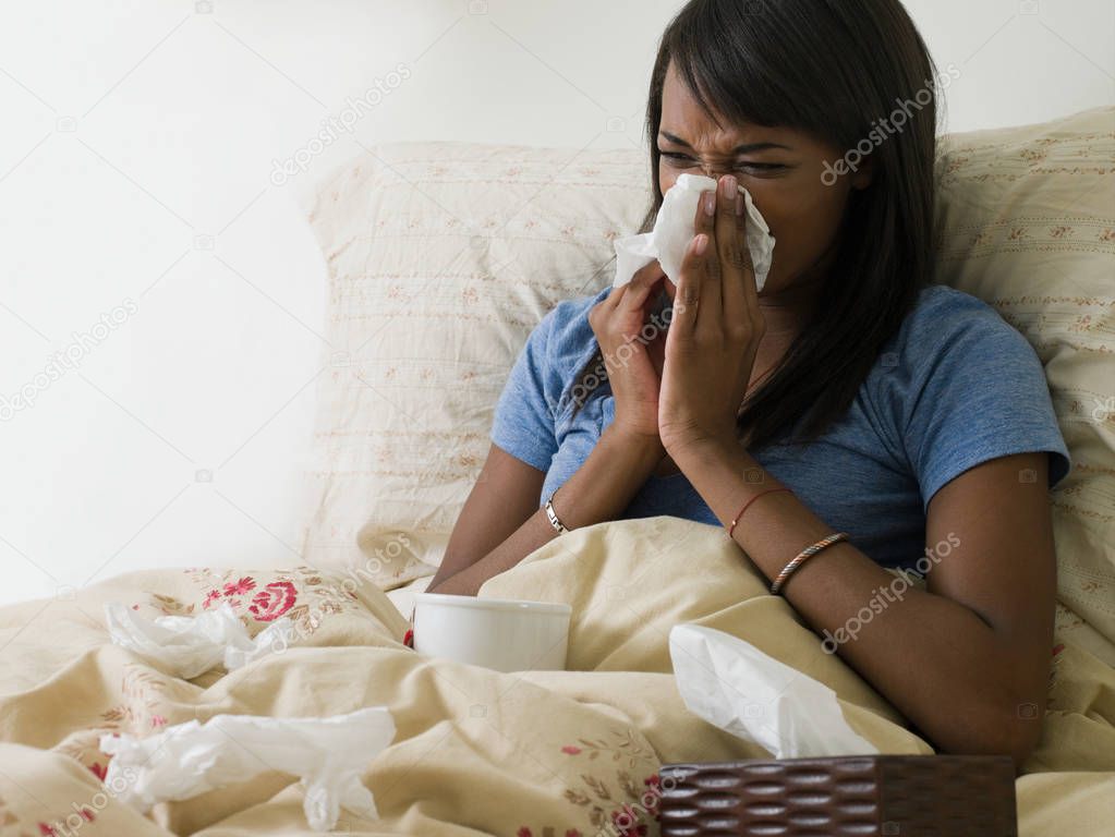 Woman lying in bed with cold