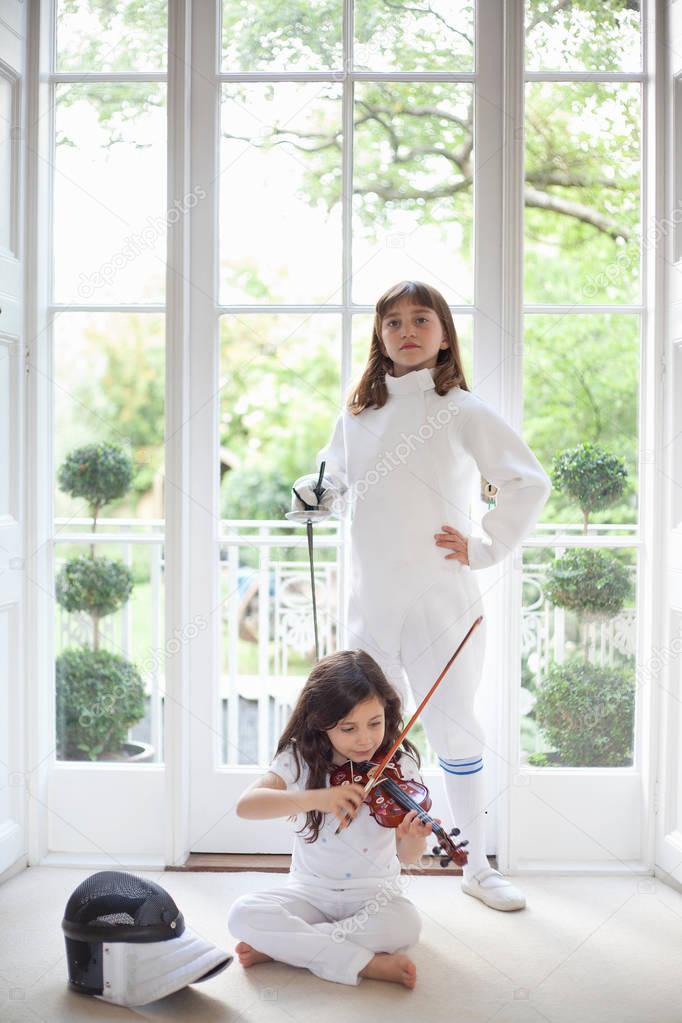 Girls with violin and fencing gear