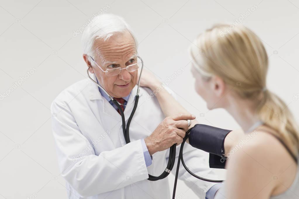 Doctor taking patient?s blood pressure