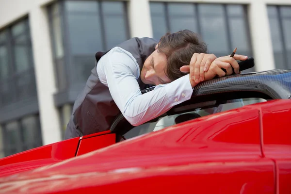 Hombre durmiendo en su coche deportivo eléctrico — Foto de Stock