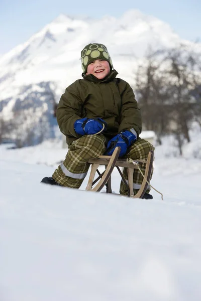 Boy sitting on sledge — Stock Photo, Image