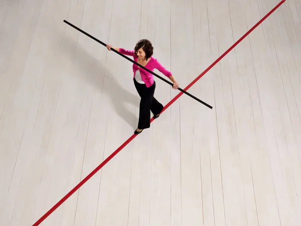 Женщина балансирует на тонкой красной линии — стоковое фото