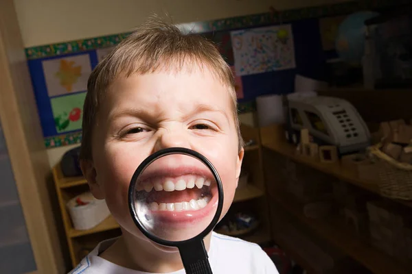 Niño sosteniendo lupa —  Fotos de Stock