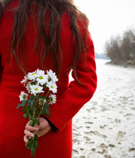 Junge Frau mit Blumen im Rücken — Stockfoto