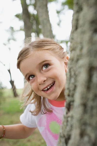 A lány elbújik a fa mögött — Stock Fotó