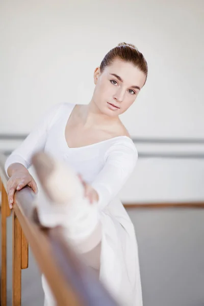 Bailarina de ballet estirándose en la barra — Foto de Stock