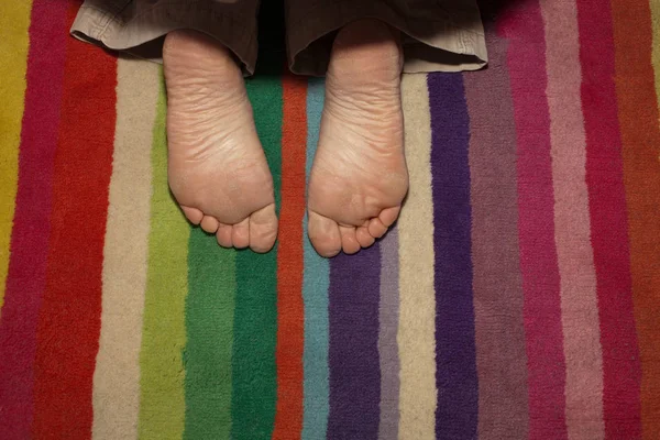 Дитячі ноги на смугастому килимку — стокове фото