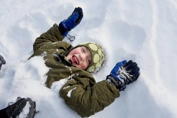 Niño acostado en la nieve —  Fotos de Stock