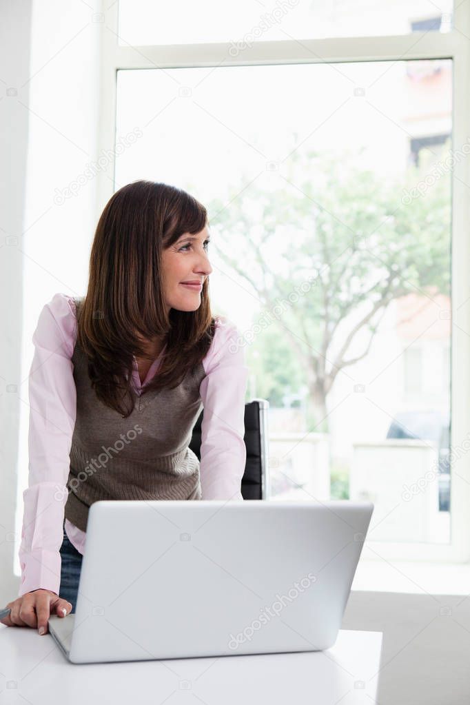 Woman standing in front of laptop
