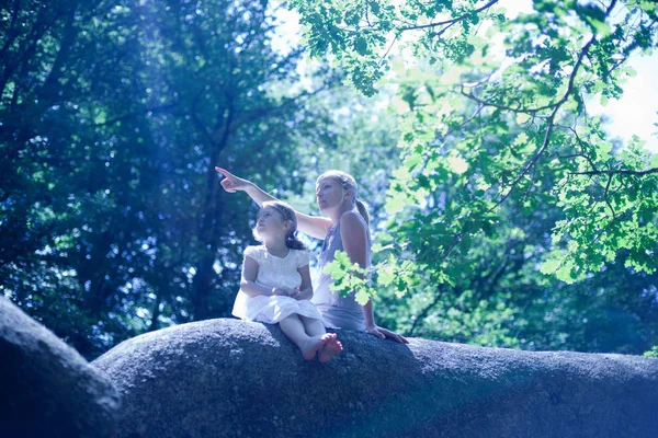 Mãe e filha sentadas na rocha — Fotografia de Stock