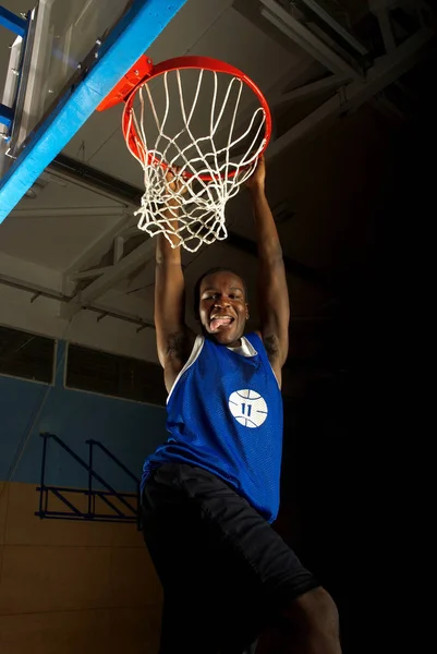 Jogador de basquete balançando no aro objetivo — Fotografia de Stock