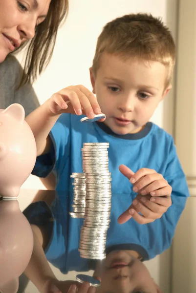 Mother and son playing with money pile — Stock Photo, Image