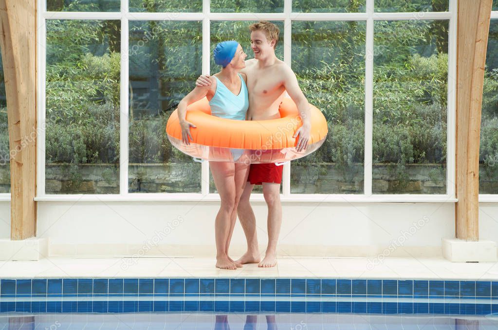 Couple standing in rubber ring by pool