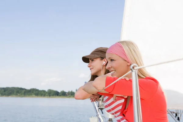 Girls sitting on boat looking aside — Stock Photo, Image