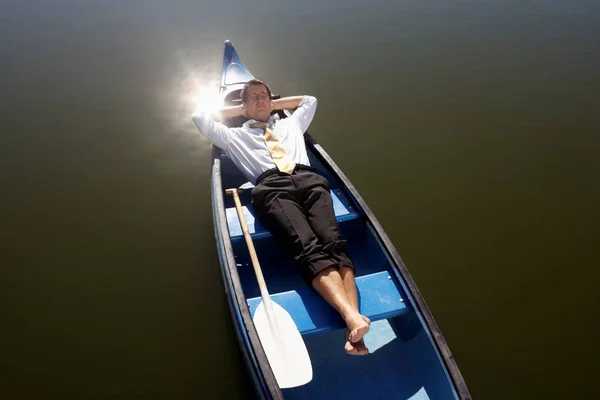 Homem deitado em canoa — Fotografia de Stock