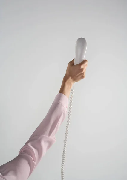 Female arm holding up telephone — Stock Photo, Image