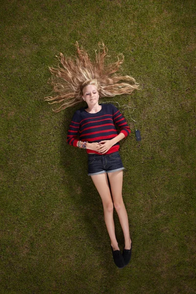 Mädchen liegt auf grünem Rasen — Stockfoto