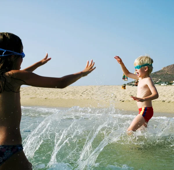 Ragazza e ragazzo giocare su spiaggia — Foto Stock