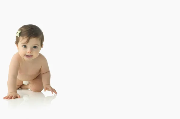 Menina do bebê rastejando e olhando para a câmera — Fotografia de Stock