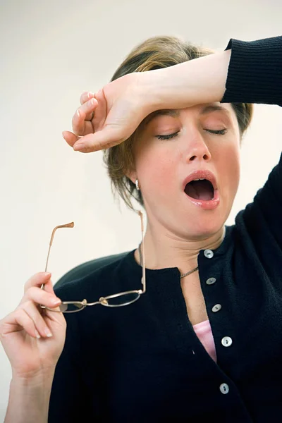 Bostezando mujer sosteniendo gafas —  Fotos de Stock