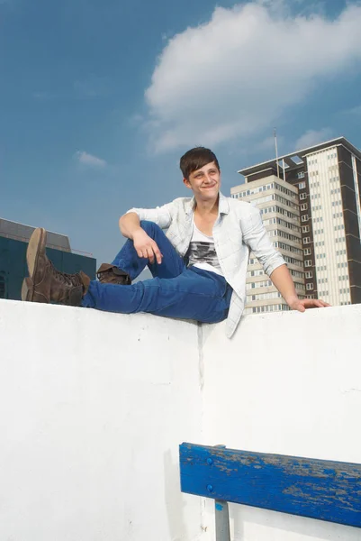Mies istuu kaupunkien katolla — kuvapankkivalokuva
