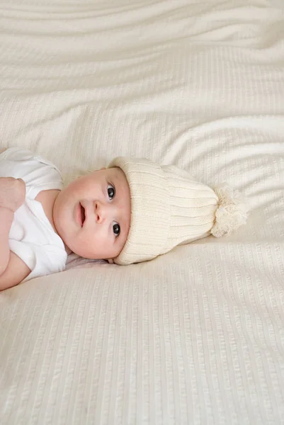 Postura bebê vestindo bobble chapéu — Fotografia de Stock