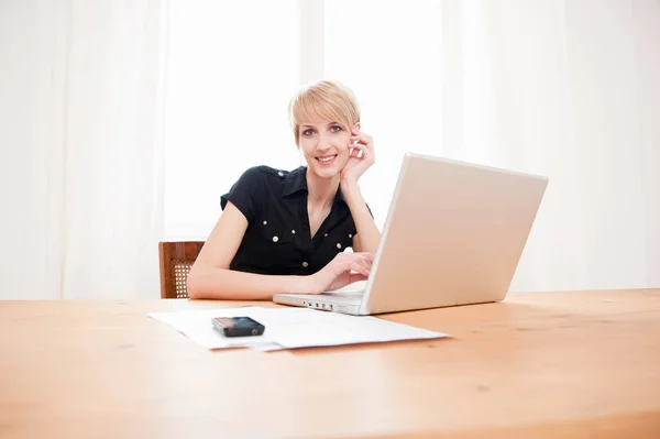 Mujer usando portátil sentado en la mesa — Foto de Stock