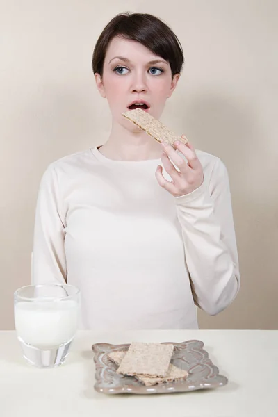 Mulher comer biscoitos salgados — Fotografia de Stock