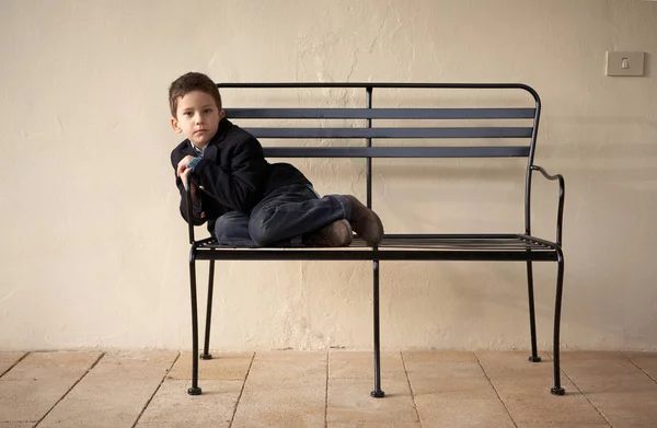 Poika istuu penkillä ulkona. — kuvapankkivalokuva