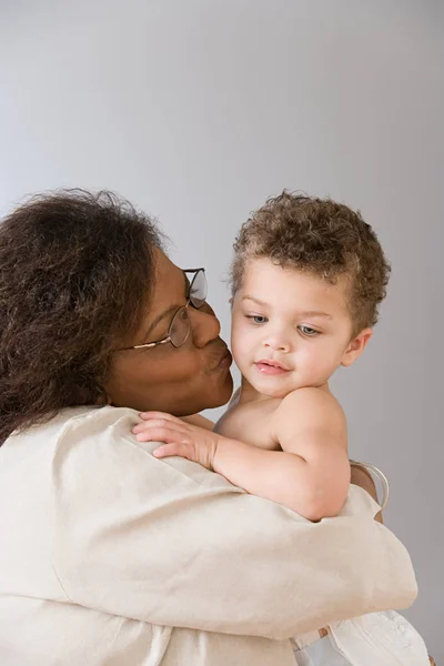Grandmother cuddling baby boy Stock Picture